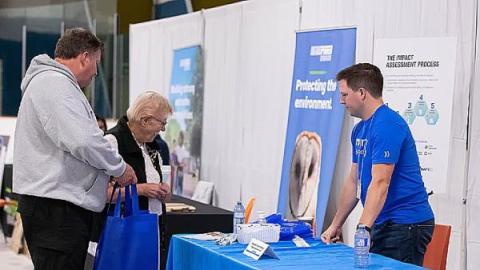 An NWMO employee explains the impact assessment process at an event An NWMO employee explains the impact assessment process at an event